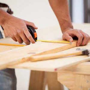 Person using tape measure on wood