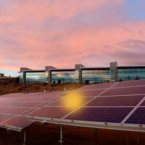 View of solar panels on top of a building under late afternoon sky.